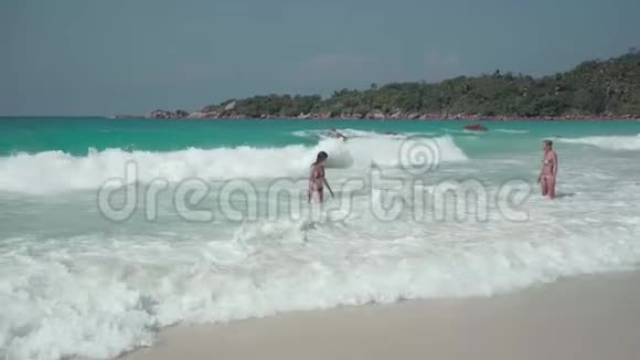 塞舌尔普拉斯林岛两个可爱的女孩在印度洋的一个异国小岛上休息休闲度假视频的预览图