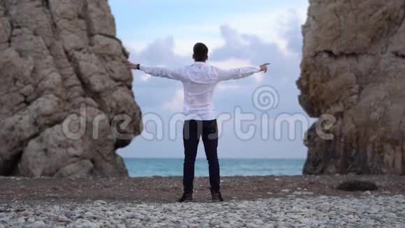 男人穿着白色衬衫和深色牛仔裤双手并肩享受自由相信未来的成功快乐的游客视频的预览图