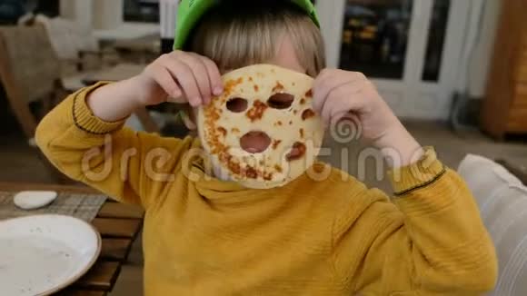 有趣的孩子在餐馆里用煎饼做面具视频的预览图
