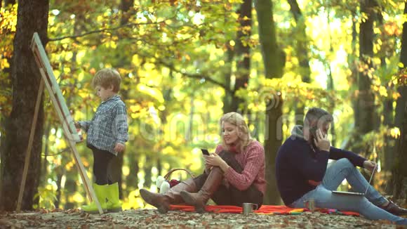 年轻的父母和孩子在一个秋天阳光明媚的日子里一起野餐和放松父亲母亲和子女儿子视频的预览图