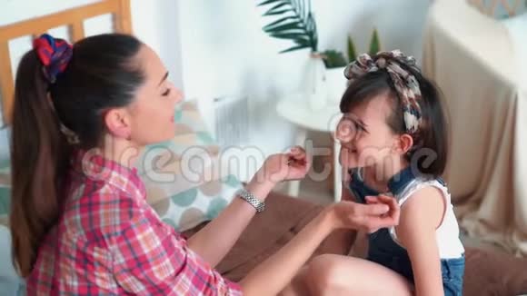 妈妈和她可爱的小女儿玩耍慢慢地亲吻她的鼻子视频的预览图