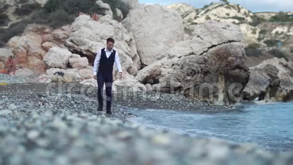 年轻的帅哥穿着古典西装在海边散步自然概念的放松塞浦路斯帕福斯视频的预览图