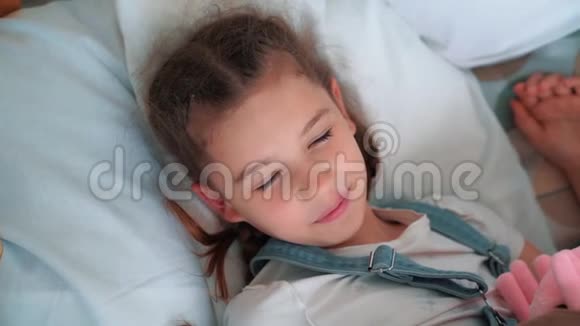 小女孩在床上睡得很香醒来后看着摄像机慢动作视频的预览图