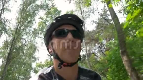 成熟的男人戴着黑墨镜喝着水骑着自行车视频的预览图