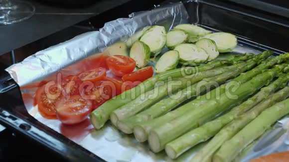 在烤炉前用橄榄油将新鲜蔬菜放入烤盘中调味视频的预览图