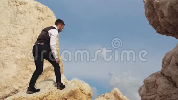年轻时尚的男人用他的脚步非常小心地爬上山塞浦路斯帕福斯视频的预览图