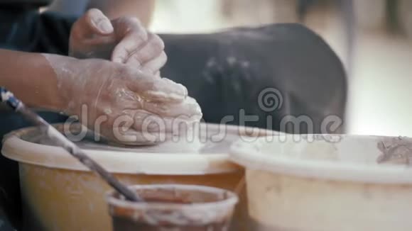 特写陶工女人用陶圈上的粘土做了一个锅视频的预览图