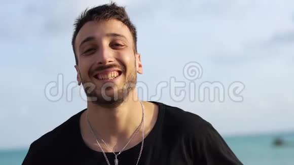 一个微笑的家伙在户外舔嘴唇的肖像独立成功的快乐胡子家伙享受生活视频的预览图