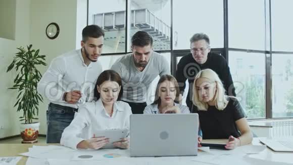 一群年轻的男人和女人正在忙着用笔记本电脑工作时间不等雇员正在做一项任务视频的预览图