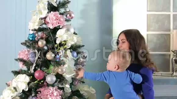 妈妈带着一个可爱的新生儿子玩圣诞树玩具视频的预览图