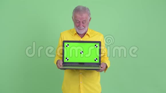快乐的老胡子商人展示笔记本电脑看上去很惊讶视频的预览图