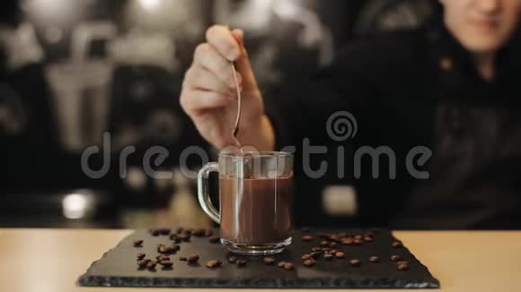 酒保把热巧克力从勺子里倒入玻璃杯里特写视频的预览图
