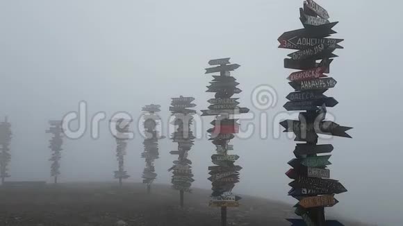 浓雾和大风在马舒克山著名的观景台有通往世界不同城市的距离标志视频的预览图