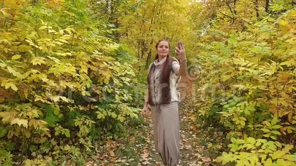 美丽的生活方式女人妆容鲜艳在秋天公园自拍视频的预览图
