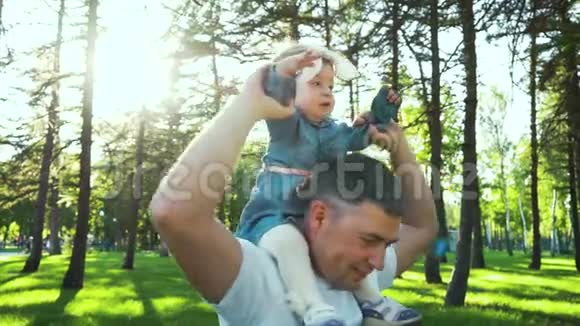 快乐的父亲抱着他的宝贝女儿在户外转悠视频的预览图