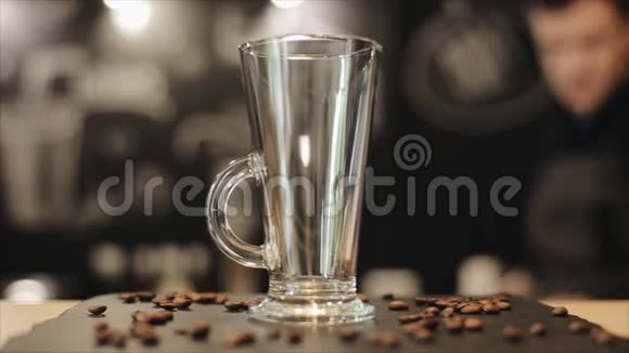 一个空杯子的特写拿铁站在酒吧柜台上上面有一些咖啡豆视频的预览图