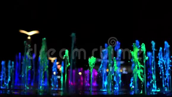 明亮的多色喷泉在暗水之上视频的预览图