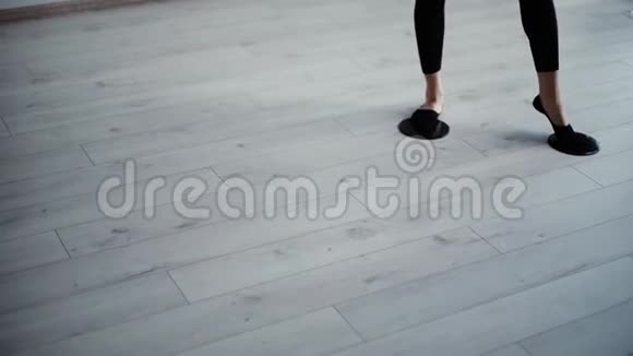 女子健身教练在健身房的地板上缓慢移动脚滑垫视频的预览图