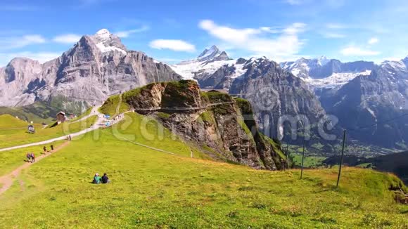 绿色夏季高山景观徒步旅行者在瑞士的第一大道上行走广受欢迎的悬崖峭壁和山脉视频的预览图