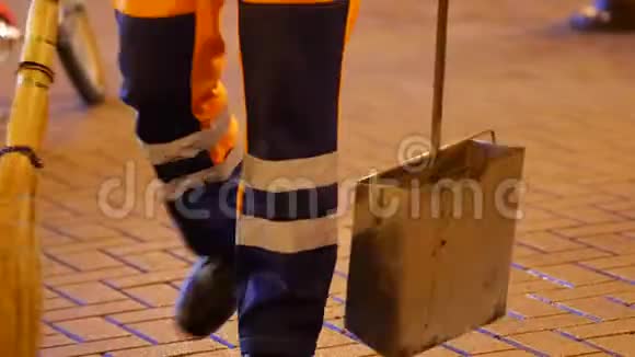 一名带着扫帚和簸箕的道路工人从人行道上清除杂物监护人视频的预览图