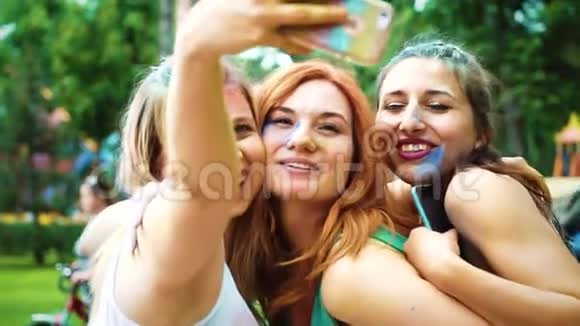 快乐的女孩涂着五颜六色的粉末笑着在霍利节后做自拍视频的预览图