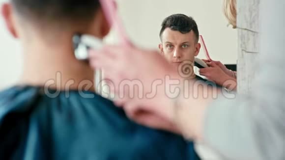 理发师在理发店为棕发男人做理发视频的预览图