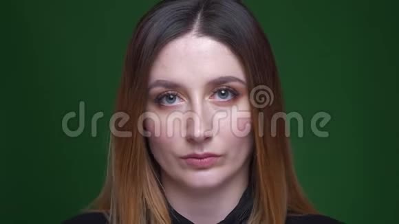 女商人的特写镜头栗色头发手表平静地进入相机并在绿色背景下向侧面视频的预览图