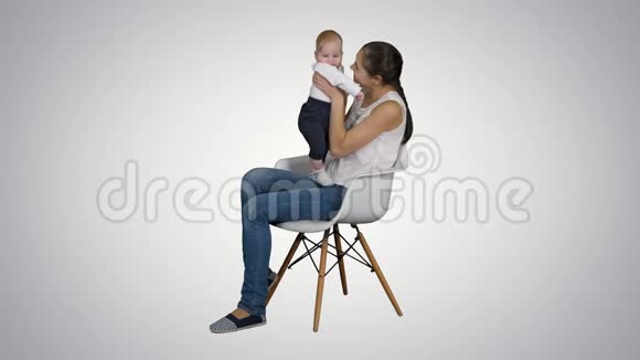 妈妈和可爱的宝宝坐在椅子上阿尔法频道视频的预览图