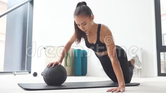 漂亮的女运动员在健身球上做俯卧撑视频的预览图