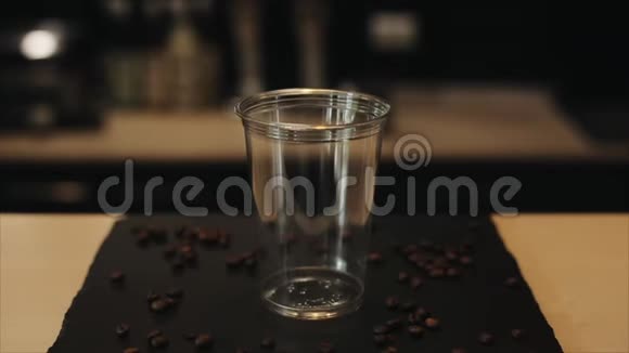 咖啡师手把冰块放进塑料杯的特写镜头视频的预览图