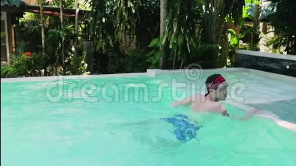 成年帅哥在一个大游泳池里游泳一个男人在游泳池边放松享受他的假期视频的预览图