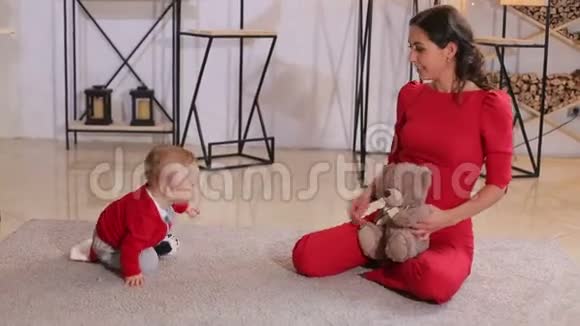 年轻妈妈带着小宝宝在家地板上的肖像圣诞节假期视频的预览图