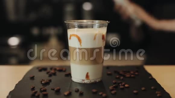 把鲜奶油放在咖啡鸡尾酒上用巧克力爆米花装饰它并在上面浇上焦糖视频的预览图