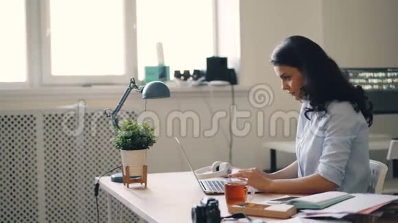 女商人用手提电脑得到好消息拍手在办公室大笑视频的预览图