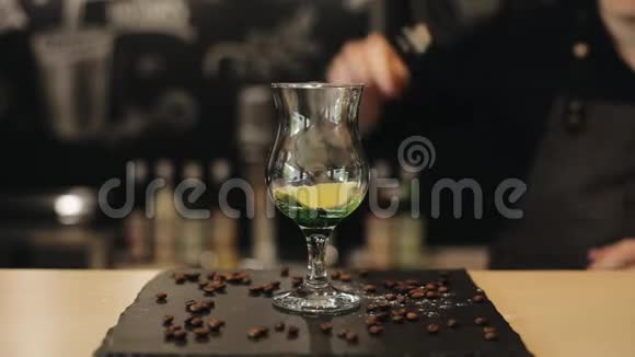 莫吉托制造的过程酒吧老板用金属勺子把石灰挤在玻璃杯里视频的预览图