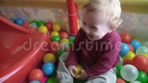 可爱的小男孩在游戏室里玩球和微笑视频的预览图