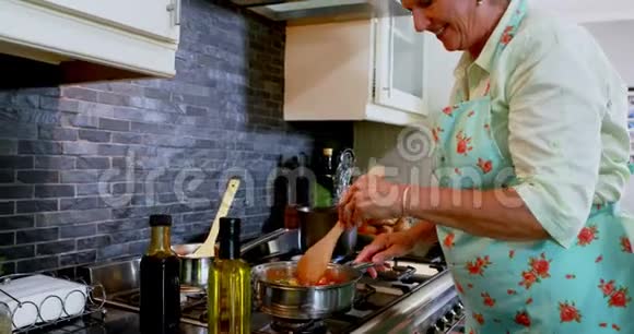 快乐的老妇人在厨房做饭视频的预览图