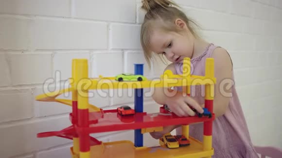 小女孩在墙边玩玩具车视频的预览图