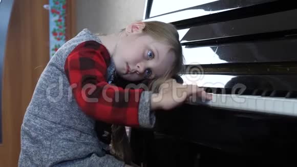 年轻的5岁女孩无聊的学习弹钢琴视频的预览图