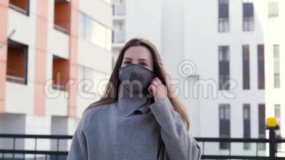 一个年轻的女人在街上摘下她的医疗面具在流行病的结束时感到高兴妇女接受医疗视频的预览图