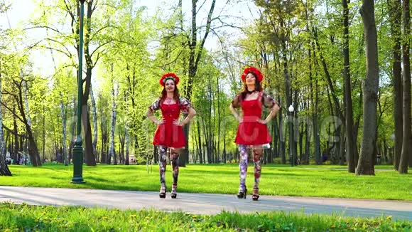 在公园里穿着民俗服装和花圈的漂亮女舞者视频的预览图