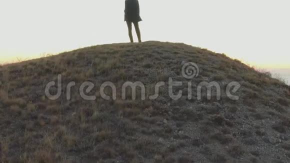 一个穿西装的人站在山顶上望着海面上的黎明视频的预览图