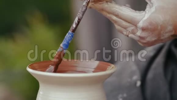 特写陶工在陶圈上的锅内部分油漆视频的预览图