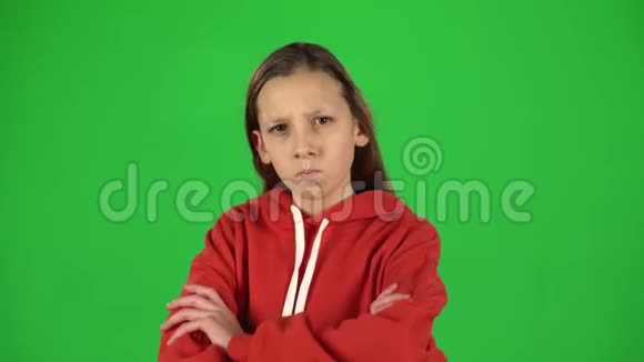 小女人生气不满意地站在她的臀部绿色背景视频的预览图