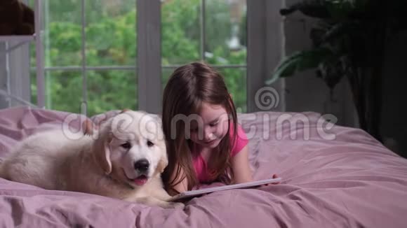 快乐的孩子和小狗一起看youtube视频的预览图