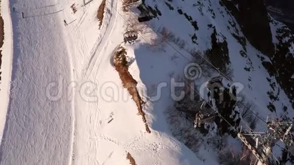 人们在冬季滑雪场的雪坡上滑雪和滑雪板空中观景滑雪电梯与乘客一起乘坐雪门视频的预览图