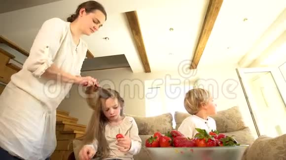 女儿吃草莓母亲梳头和哥哥浆果酱视频的预览图