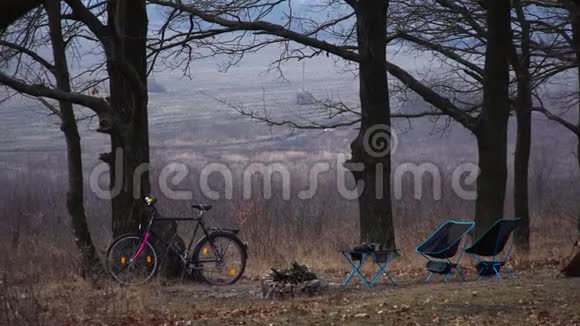 野营椅和便携式桌子轻巧紧凑的旅行用品装备齐全的营地秋天的森林天气不错自行车木柴视频的预览图