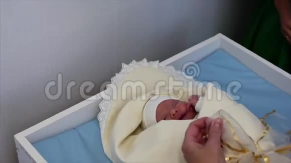 母亲在分娩后把新生婴儿襁褓中新生儿出生后躺在床上看着视频的预览图