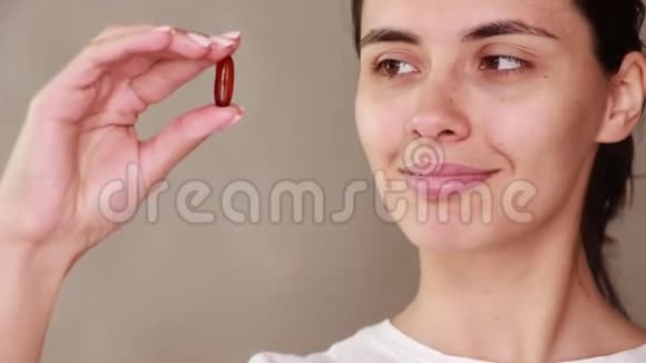 维生素和食物补充剂女人手的药丸微笑的女孩拿着药片视频的预览图